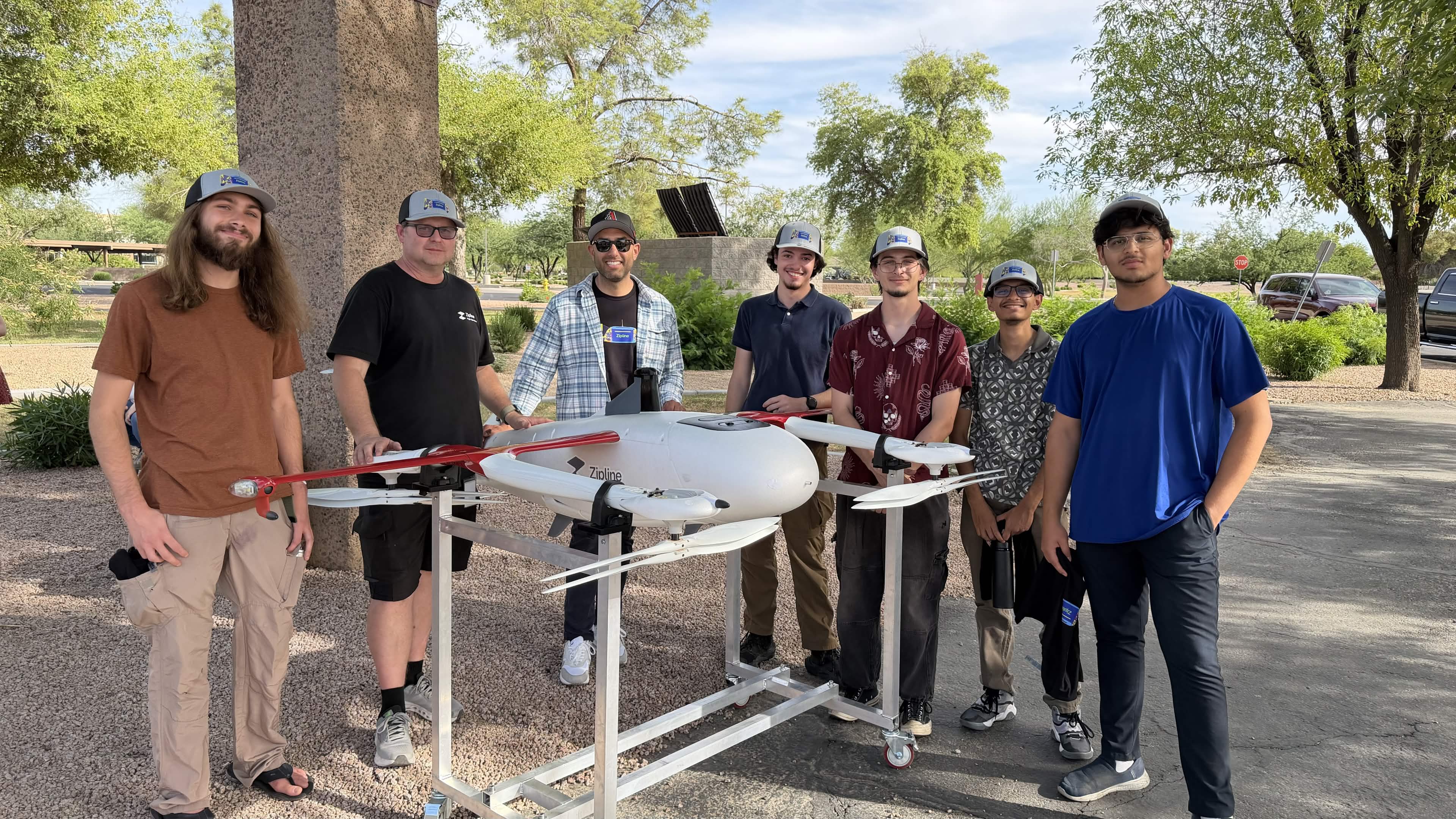 Drone Devils members standing with a full-size Zipline delivery drone